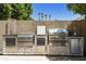 A fully equipped outdoor kitchen featuring stainless steel appliances and a stone facade at 5957 W Robin Ln, Glendale, AZ 85310