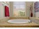 Soaking tub in the bathroom is surrounded by decorative tile and offers a peaceful retreat at 6231 E Mark Way # 14, Cave Creek, AZ 85331