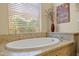 Bright bathroom featuring a standalone tub with stone surround and a large window at 6231 E Mark Way # 14, Cave Creek, AZ 85331