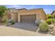 Two-car garage with a brick driveway and well-manicured landscaping surrounding it at 6231 E Mark Way # 14, Cave Creek, AZ 85331