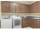 Laundry room featuring full sized washer and dryer, wooden cabinets, and a laminate countertop with stainless sink at 6231 E Mark Way # 14, Cave Creek, AZ 85331