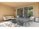 Covered patio area offering cushioned seating, a woven outdoor table set, and access via sliding glass doors at 6231 E Mark Way # 14, Cave Creek, AZ 85331
