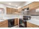 Functional kitchen with wooden cabinets, black appliances, light countertops, and neutral-colored walls at 7101 W Beardsley Rd # 542, Glendale, AZ 85308