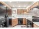 Well-lit kitchen featuring wooden cabinets, black appliances, tile floors, and neutral wall paint at 7101 W Beardsley Rd # 542, Glendale, AZ 85308