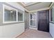 Entryway featuring a solid door, windows with blinds, and a security door at 7132 N 63Rd Dr, Glendale, AZ 85301
