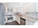 Bright kitchen features new stainless steel appliances, grey backsplash, and quartz countertops at 7132 N 63Rd Dr, Glendale, AZ 85301