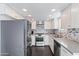 Modern kitchen featuring stainless steel appliances, white cabinets, and stone countertops at 7132 N 63Rd Dr, Glendale, AZ 85301