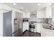 Modern kitchen with stainless steel appliances, a stone backsplash, and white cabinetry at 7132 N 63Rd Dr, Glendale, AZ 85301