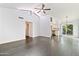Open concept living room with gray vinyl floors, vaulted ceiling, and kitchen views at 7132 N 63Rd Dr, Glendale, AZ 85301