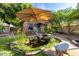 Charming backyard featuring a tranquil pond with stone edging and a shady umbrella table at 725 W Portland St, Phoenix, AZ 85007