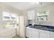 Functional kitchen featuring bright white cabinets, blue counters, and views through a window at 725 W Portland St, Phoenix, AZ 85007