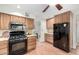 Updated kitchen with wood cabinets, granite counters, and black appliances at 725 W Portland St, Phoenix, AZ 85007