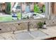 Close up of the kitchen sink with a large window overlooking a lush, green garden with a bridge at 725 W Portland St, Phoenix, AZ 85007