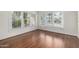 Sun-filled living room featuring freshly refinished hardwood floors and large windows at 725 W Portland St, Phoenix, AZ 85007