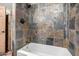Shower featuring decorative stone tile work and a white bathtub at 725 W Portland St, Phoenix, AZ 85007
