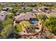 Beautiful aerial shot of the desert home highlighting the pool, patio, lush landscaping, and privacy at 7335 E Quail Track Rd, Scottsdale, AZ 85266