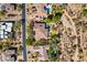 Aerial view of property showcasing circular pool, mature trees, large roof, and a circular driveway at 7335 E Quail Track Rd, Scottsdale, AZ 85266