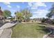 Expansive backyard featuring lush green grass, mature trees, and a charming patio area with hot tub at 7335 E Quail Track Rd, Scottsdale, AZ 85266