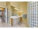 Bright bathroom features a glass block shower, vanity, and a large mirror reflecting natural light at 7335 E Quail Track Rd, Scottsdale, AZ 85266