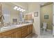 Bathroom with double sinks, wooden cabinets, granite counter, and separate toilet area at 7335 E Quail Track Rd, Scottsdale, AZ 85266