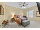 Warm bedroom showcases a ceiling fan, shuttered window, and a cozy sitting area at 7335 E Quail Track Rd, Scottsdale, AZ 85266