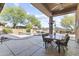 Charming covered patio overlooking the pool, rock waterfall, and desert landscaping at 7335 E Quail Track Rd, Scottsdale, AZ 85266