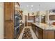 Spacious kitchen featuring wood cabinetry, stainless steel appliances, and a granite island at 7335 E Quail Track Rd, Scottsdale, AZ 85266