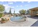 Backyard pool features rock waterfall accents, mature cacti, and desert landscaping at 7335 E Quail Track Rd, Scottsdale, AZ 85266