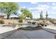 Inviting pool with rock waterfall feature, desert landscaping, and spacious stone patio at 7335 E Quail Track Rd, Scottsdale, AZ 85266