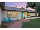 Inviting home featuring a bright teal front door, brick walkway, and cozy blue chairs at 7533 N 8Th St, Phoenix, AZ 85020