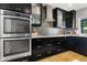 Gourmet kitchen features stainless steel double ovens, sleek dark cabinets, and decorative backsplash at 7533 N 8Th St, Phoenix, AZ 85020