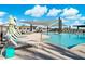 Resort-style pool with lounge chairs, sunshades, and clear blue water creating a relaxing community space at 7836 E Quintana Ave, Mesa, AZ 85212