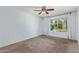 Cozy bedroom with a ceiling fan, carpet flooring, and a bright window at 820 W Hononegh Dr, Phoenix, AZ 85027