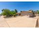 Well-maintained single-story home featuring a spacious driveway, desert landscaping, and a two-car garage under a clear sky at 820 W Hononegh Dr, Phoenix, AZ 85027