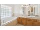 Bright bathroom featuring double sinks, a soaking tub, and a tile accent wall at 8343 W Calle Lejos --, Peoria, AZ 85383