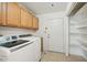 Bright laundry room features wooden cabinets, newer washer and dryer, and built-in shelves at 8343 W Calle Lejos --, Peoria, AZ 85383