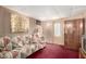 Retro finished basement with paneled walls, patterned sofa and red carpet at 8632 E Delilah Ave, Mesa, AZ 85208
