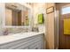 A traditional bathroom with a white vanity, mirror, and floral wallpaper at 8632 E Delilah Ave, Mesa, AZ 85208