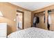 A cozy bedroom with wood paneling and a closet, next to a bathroom at 8632 E Delilah Ave, Mesa, AZ 85208