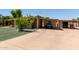 Exterior view showcasing carport, lush lawn, and mature tree in front of the residence at 8632 E Delilah Ave, Mesa, AZ 85208