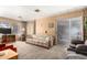 Cozy living room with carpeted floors, wood-paneled walls, and sliding glass doors to patio at 8632 E Delilah Ave, Mesa, AZ 85208