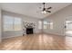 Bright living room featuring a decorative fireplace, tiled floors, a ceiling fan, and windows at 9002 W Caribbean Ln, Peoria, AZ 85381
