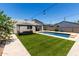 An expansive backyard with artificial grass, outdoor lighting and a swimming pool at 1005 E Weldon Ave, Phoenix, AZ 85014