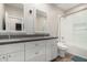Bathroom featuring double sinks, white cabinets, a toilet, and a tiled shower at 1005 E Weldon Ave, Phoenix, AZ 85014