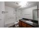 Bright bathroom features a granite-topped vanity with a sink, a tile floor, and a shower-over-tub combination at 11375 E Sahuaro Dr # 1053, Scottsdale, AZ 85259