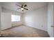 This bedroom includes neutral carpeting, a ceiling fan, and a window for comfortable and stylish living at 11375 E Sahuaro Dr # 1053, Scottsdale, AZ 85259