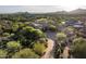 An aerial view of a desert home with a long driveway, lush landscaping, and mountain views at 11548 E Salero Dr, Scottsdale, AZ 85262