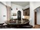 Home bar area with dark cabinets, granite countertop, unique lighting, and stone columns at 11548 E Salero Dr, Scottsdale, AZ 85262