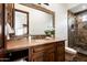 Bathroom with stone vanity, framed mirror, and walk-in shower with tiled surround at 11548 E Salero Dr, Scottsdale, AZ 85262