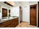 Bathroom features dual sinks, granite countertops, wood cabinets, and decorative mirrors at 11548 E Salero Dr, Scottsdale, AZ 85262